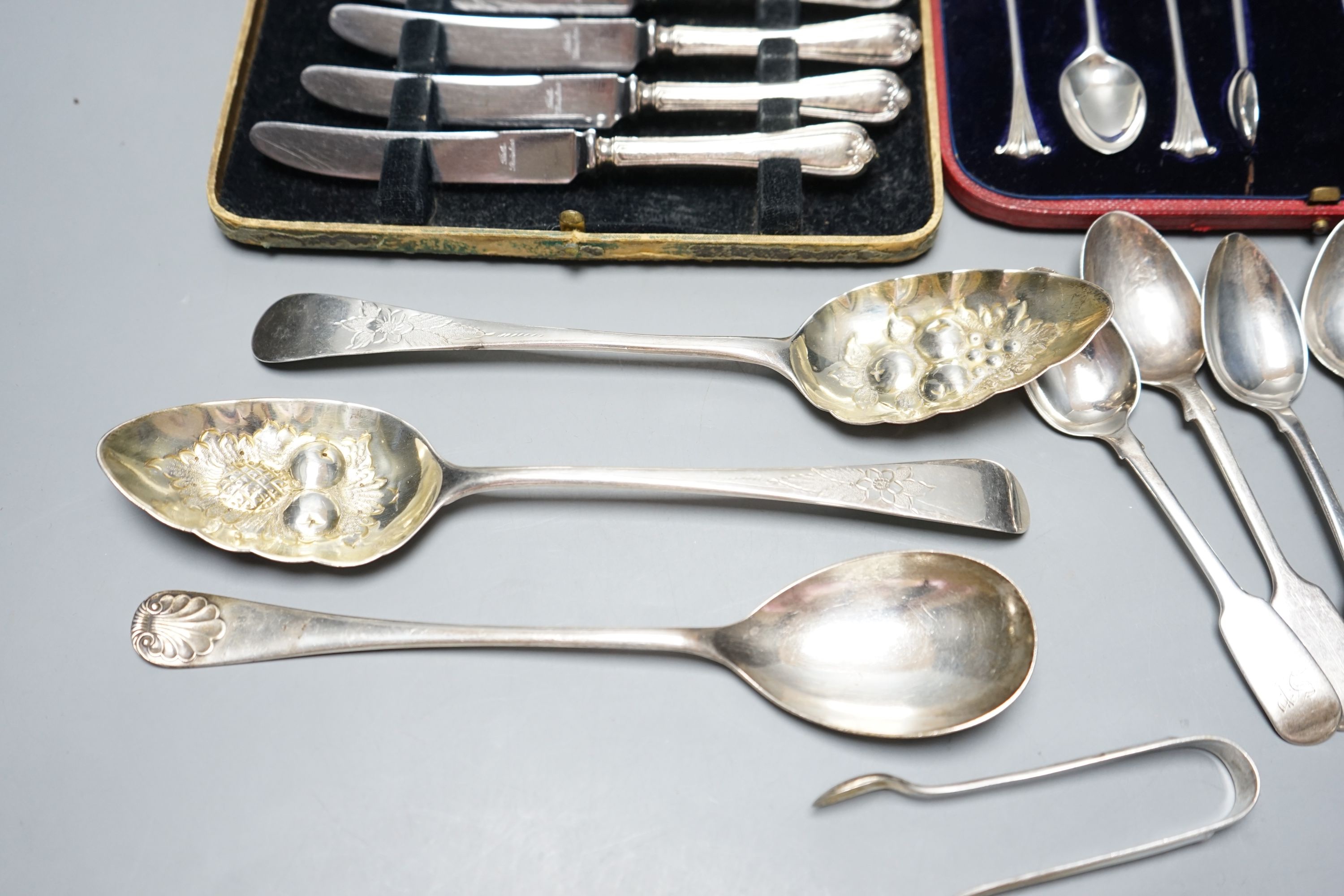 Two George III silver 'berry' spoons, seven other silver spoons, pair of silver tongs, a Swedish white metal teaspoons and two cased sets including silver teaspoons.